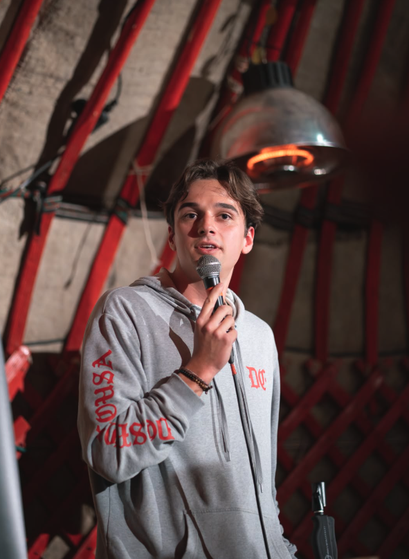 Nico Krüger mit Mikrofon im Hoodie